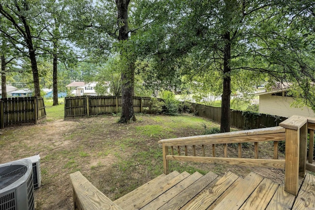 view of yard featuring central AC unit and a wooden deck