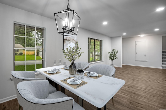 dining area with dark wood-type flooring and a chandelier