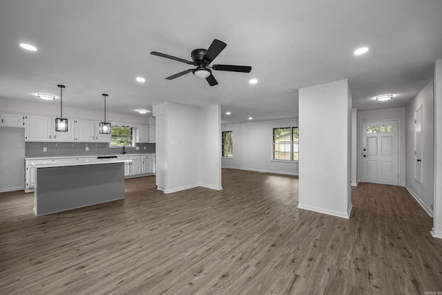 kitchen featuring pendant lighting, a wealth of natural light, white cabinets, and hardwood / wood-style flooring