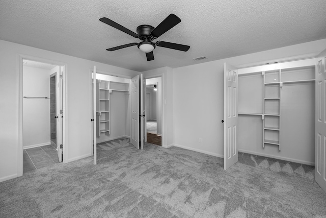 unfurnished bedroom with a textured ceiling, ceiling fan, and light colored carpet