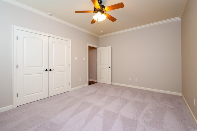 unfurnished bedroom with ceiling fan, light colored carpet, a closet, and crown molding