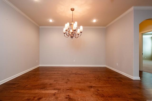 unfurnished room featuring a notable chandelier, dark hardwood / wood-style floors, and ornamental molding