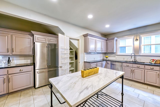 kitchen featuring light tile patterned flooring, tasteful backsplash, sink, gray cabinetry, and stainless steel appliances