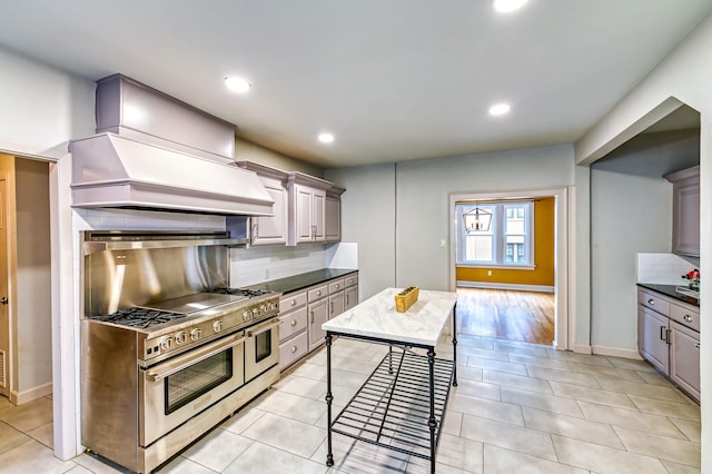 kitchen with a kitchen island, gray cabinetry, range with two ovens, decorative backsplash, and light tile patterned floors