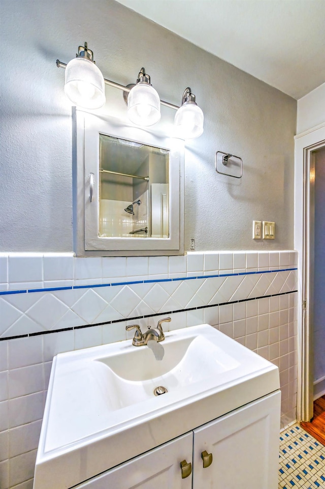 bathroom with vanity and tile walls