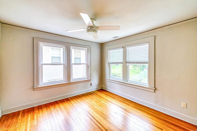 spare room with a wealth of natural light, light hardwood / wood-style floors, and ceiling fan