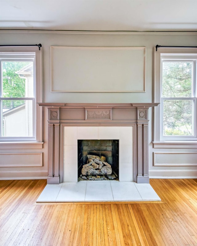 details featuring a tiled fireplace and hardwood / wood-style floors