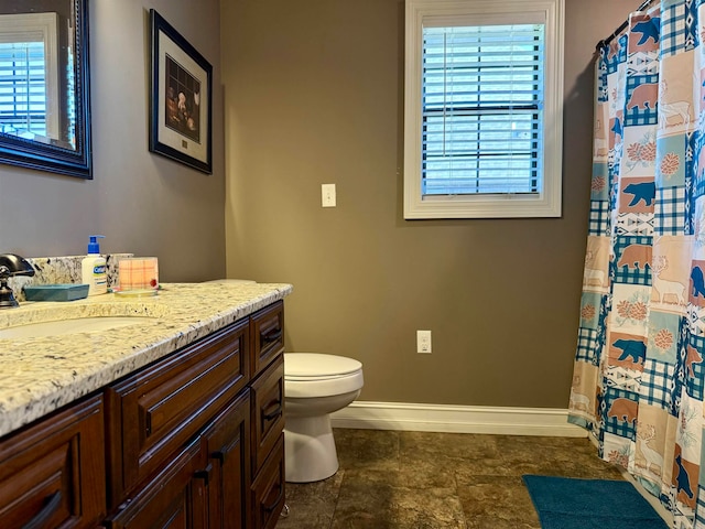 bathroom featuring vanity, toilet, and a healthy amount of sunlight