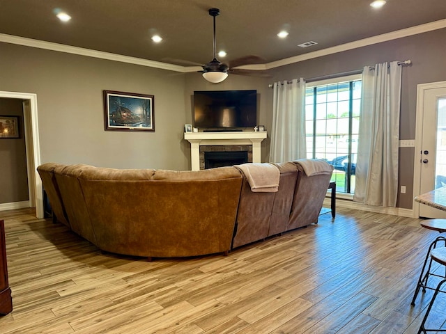 living room with ornamental molding, light hardwood / wood-style floors, and ceiling fan