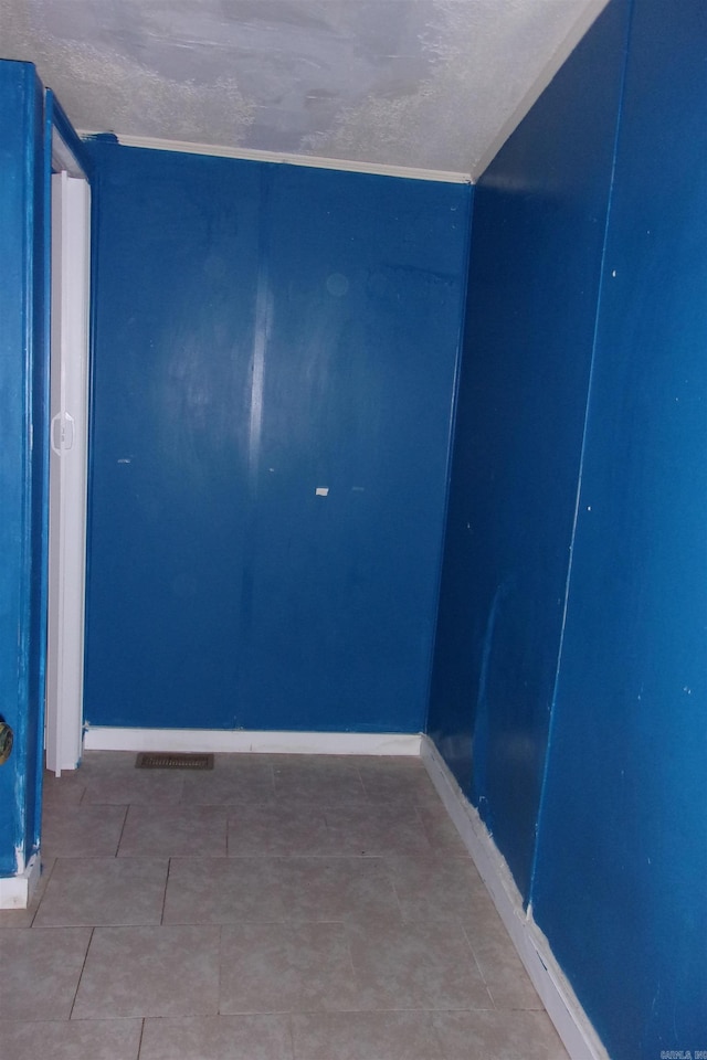 spare room featuring a textured ceiling and tile patterned floors