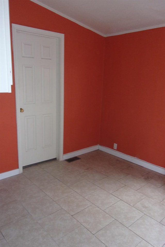 unfurnished room featuring light tile patterned floors, vaulted ceiling, and ornamental molding