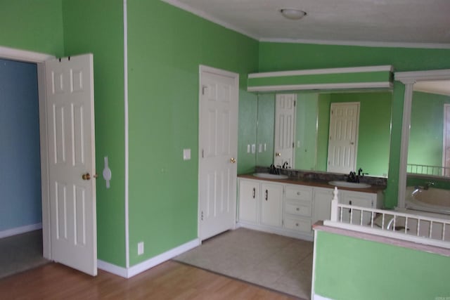 kitchen with white cabinets, light hardwood / wood-style flooring, crown molding, and sink