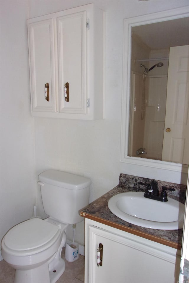 bathroom with a tile shower, tile patterned flooring, vanity, and toilet