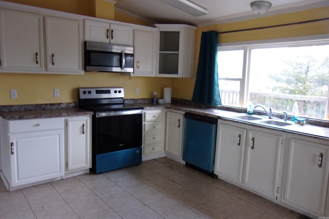 kitchen with sink, white cabinets, lofted ceiling, stainless steel appliances, and light tile patterned floors