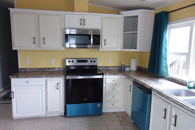 kitchen featuring appliances with stainless steel finishes, ornamental molding, lofted ceiling, and white cabinetry