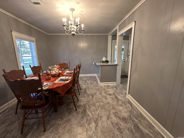 dining space featuring a chandelier, baseboards, and crown molding