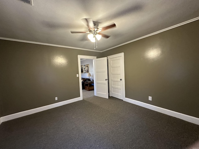 unfurnished bedroom with dark carpet, ceiling fan, crown molding, and baseboards