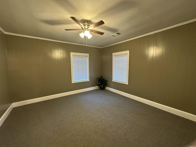 carpeted empty room featuring visible vents, ceiling fan, ornamental molding, and baseboards
