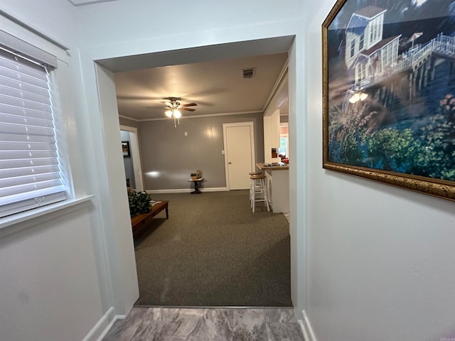 hallway featuring ornamental molding and carpet flooring