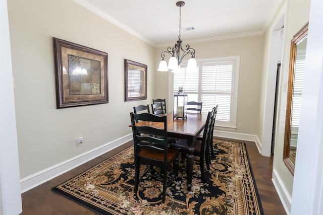 dining area with ornamental molding, a notable chandelier, and dark hardwood / wood-style flooring