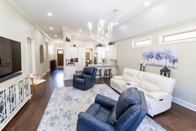 living room with a chandelier, dark hardwood / wood-style flooring, and crown molding