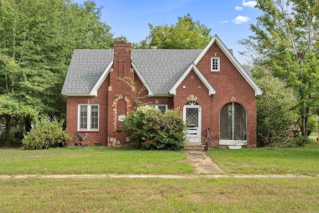 tudor-style house featuring a front lawn