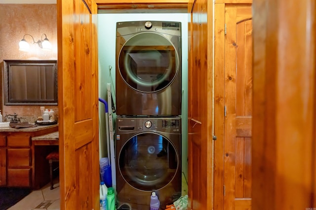 clothes washing area featuring stacked washer / drying machine and tile patterned floors