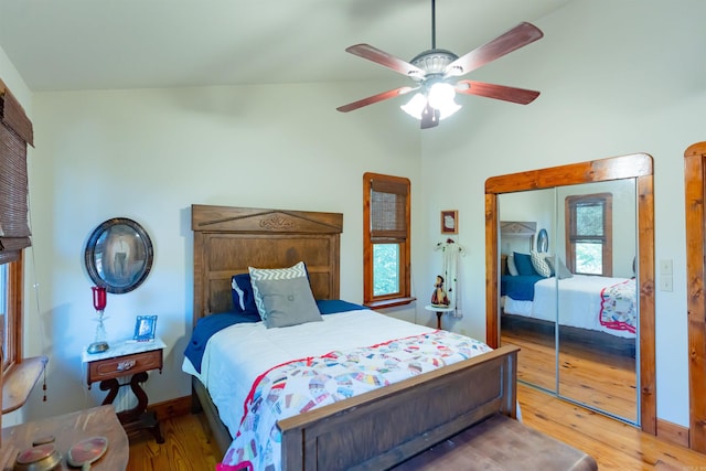 bedroom featuring light hardwood / wood-style flooring, vaulted ceiling, ceiling fan, and a closet