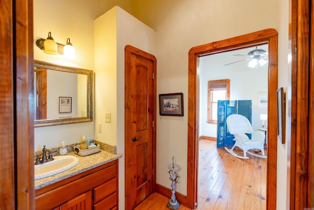 bathroom with wood-type flooring, ceiling fan, and vanity