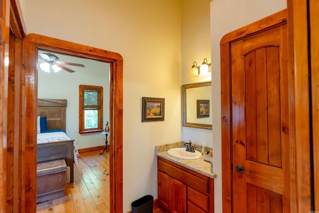 bathroom with ceiling fan, vanity, and hardwood / wood-style floors