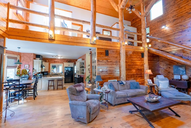 living room with high vaulted ceiling, a wealth of natural light, and light hardwood / wood-style flooring