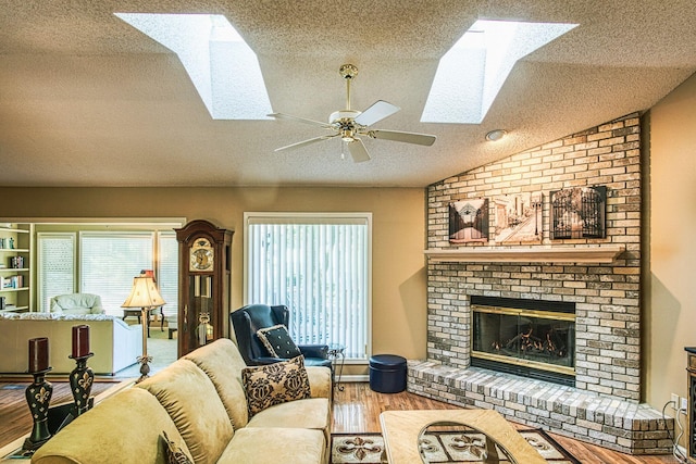 living room with a fireplace, a textured ceiling, lofted ceiling, ceiling fan, and hardwood / wood-style flooring