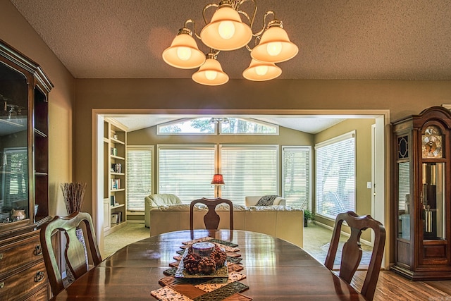 carpeted dining room featuring a textured ceiling, lofted ceiling, and a chandelier