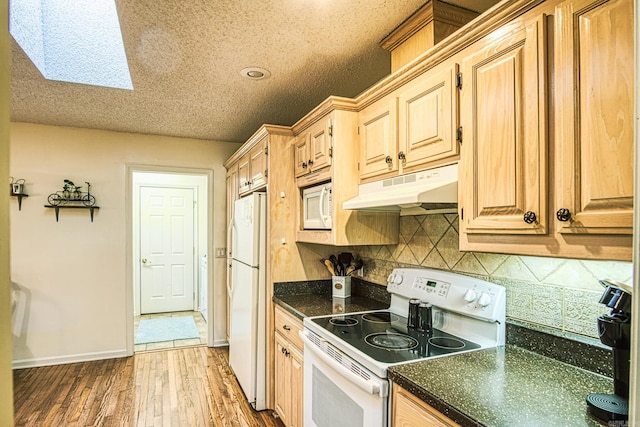 kitchen featuring a textured ceiling, white appliances, a skylight, light brown cabinets, and dark hardwood / wood-style flooring