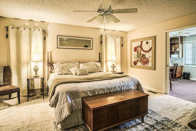 bedroom with ceiling fan, carpet flooring, and a textured ceiling