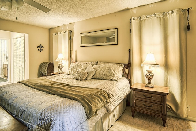 carpeted bedroom with ceiling fan, a textured ceiling, and a closet