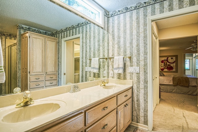 bathroom featuring ceiling fan, a textured ceiling, and vanity