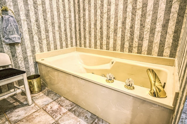 bathroom with a tub to relax in and tile patterned floors