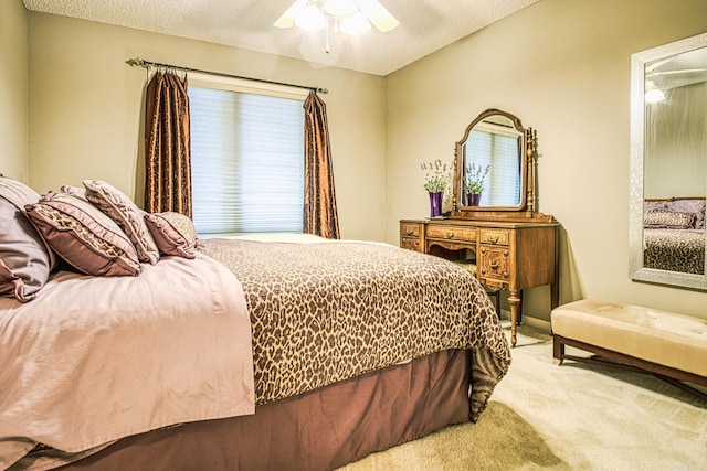 bedroom featuring ceiling fan, a textured ceiling, and light carpet