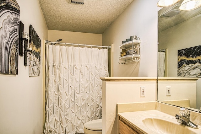 bathroom with a textured ceiling, vanity, toilet, and a shower with shower curtain