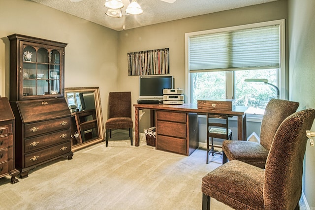 carpeted office space featuring ceiling fan and a textured ceiling