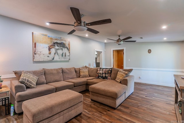 living room featuring ceiling fan and dark wood-type flooring