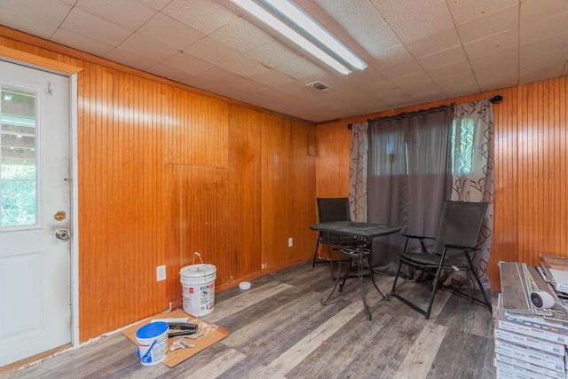 living area with wood walls and hardwood / wood-style floors