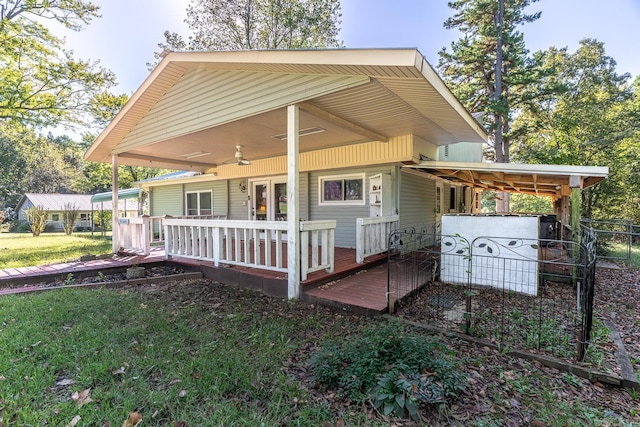 rear view of property with a lawn, a wooden deck, and ceiling fan