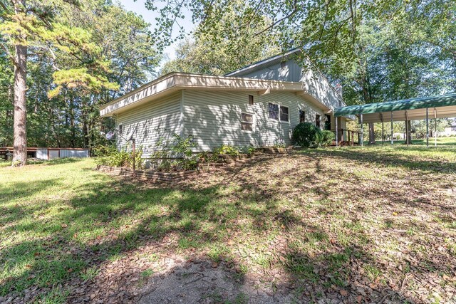 view of side of home featuring a yard and a carport