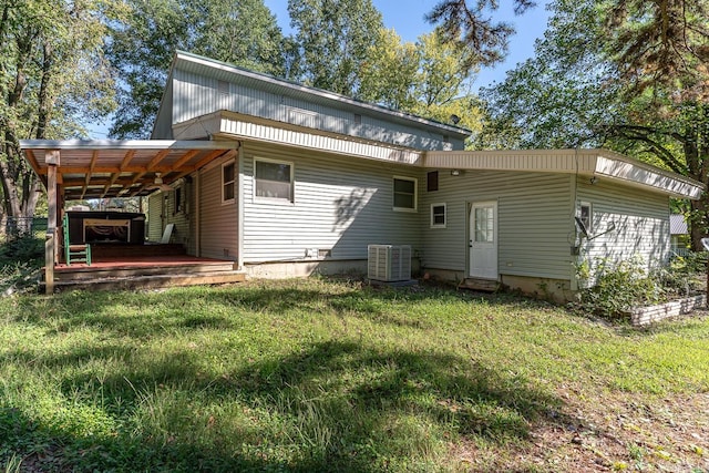 rear view of house with a lawn and central AC unit