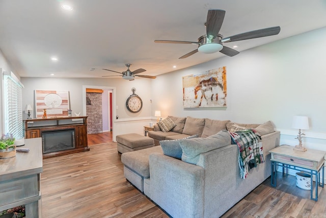 living room featuring hardwood / wood-style floors and ceiling fan