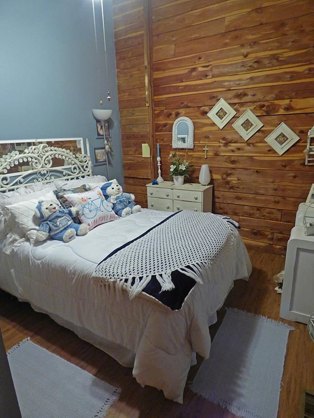 bedroom featuring wooden walls and dark hardwood / wood-style floors