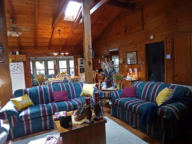 living room with wood-type flooring, wooden walls, a skylight, and high vaulted ceiling