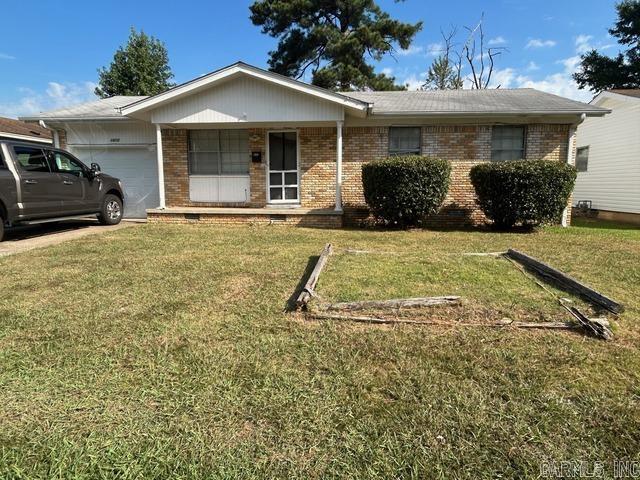 single story home featuring a porch, a garage, and a front lawn